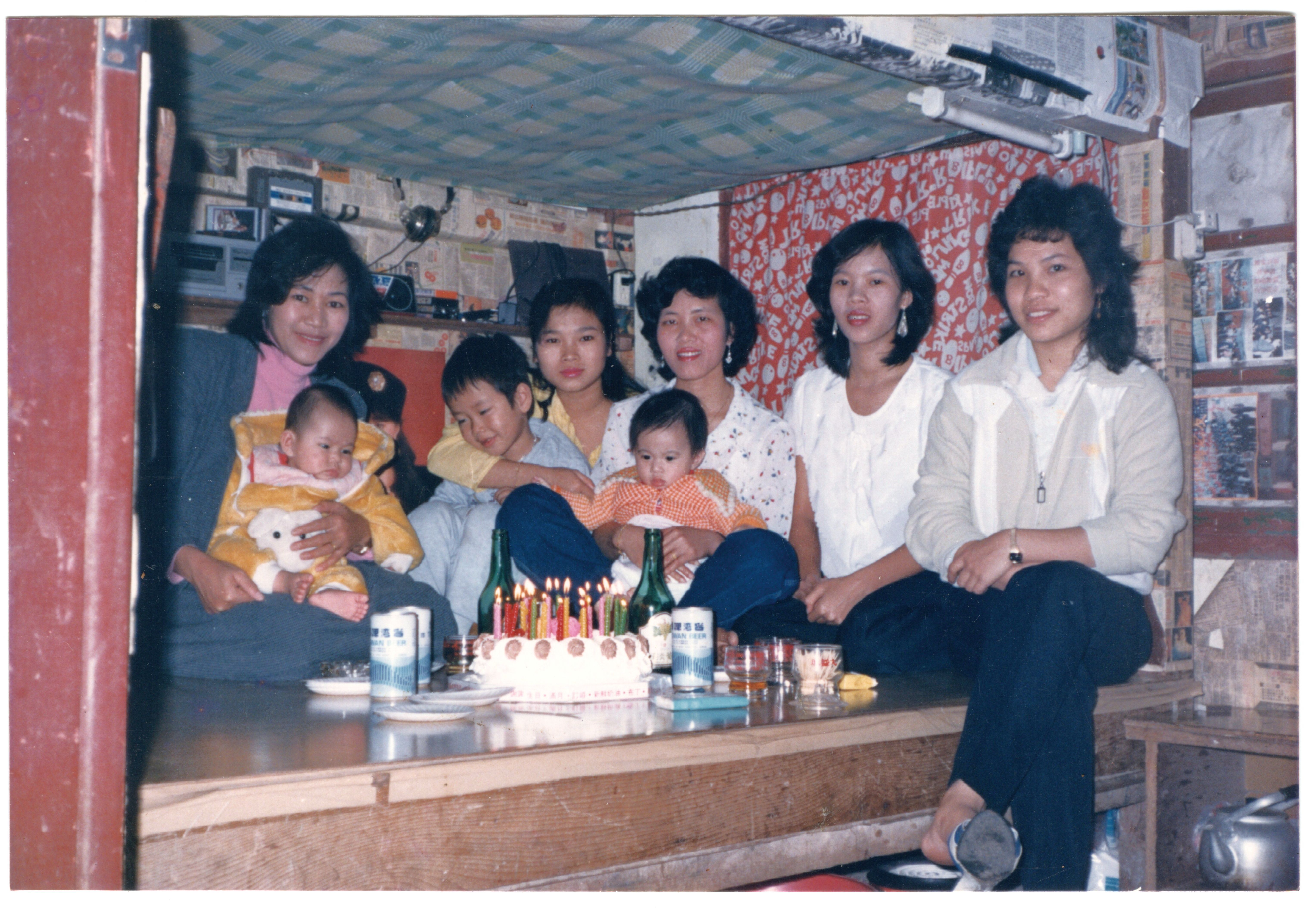 阮氏霞(左前嬰，1986年生)依偎在母親懷裡。澎湖難民營關閉後，他們全家移居台灣